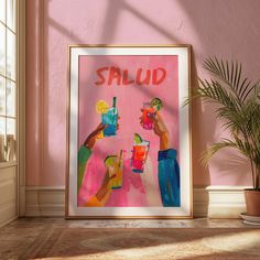 a pink wall with a painting on it that says salud and two people holding drinks