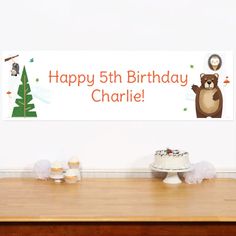 there is a sign that says happy 5th birthday charlie on the wall next to cupcakes