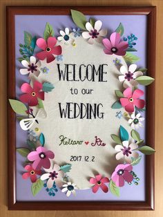 a paper flower frame with the words welcome to our wedding