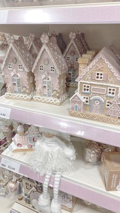 some pink and white gingerbread houses are on shelves