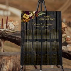 a wooden sign with flowers on it sitting in front of an outdoor table set up for a wedding