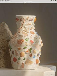 a white vase with shells and seashells on it