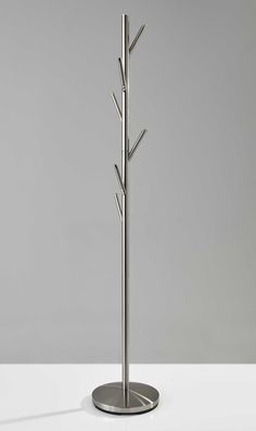 a tall metal tree with four branches on it's base is shown in front of a gray background