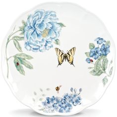 a white plate with blue flowers and butterflies on it