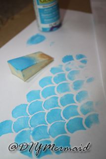 a piece of paper with blue watercolors on it next to a paint roller