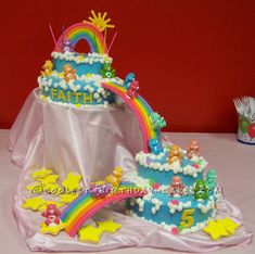 a birthday cake with rainbows and clouds on it sitting on top of a table