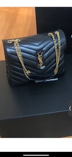 SL Saint Laurent LouLou Small Shoulder Bag Black calfskin Gold hardware Height: 6.7" Length: 9" Depth: 3.5" Like New condition - this was a store display bag. Has signs of being touched and handled - small scratches from fingernails in the pocket. It was never carried after purchasing. Comes with tag, dust bag, and booklets. Slight Wear and Tear, Comes with Original YSL Large box Bag Display, Bronze Hardware, Shoulder Bag Black, Store Display, Small Shoulder Bag, Medium Bags, Ysl Bag, Gold Hardware, Calf Skin