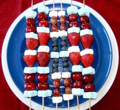 fruit skewers arranged in the shape of an american flag on a blue plate