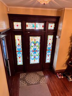 an entryway with stained glass doors and wooden floors