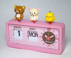 three little toy animals sitting on top of a pink clock with the time 1 noon