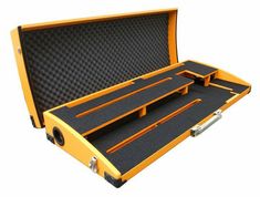 an open yellow case with black foam and metal latches on the bottom half is shown