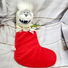 a stuffed animal in a red stocking on a bed