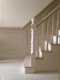 an empty room with white walls and stairs