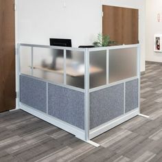 an office cubicle with a laptop on the desk