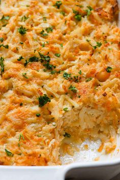 a casserole dish filled with macaroni and cheese, garnished with parsley