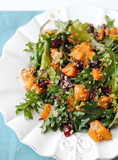 a white plate topped with salad on top of a blue table