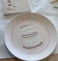 a white plate with a cake on it sitting on a table next to some crayons