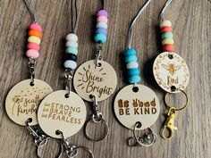 four wooden key chains with different sayings on them