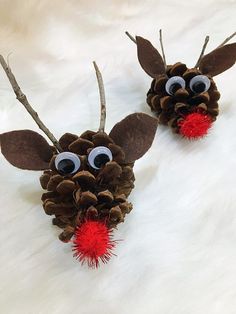 two pine cones with googly eyes and antlers on them