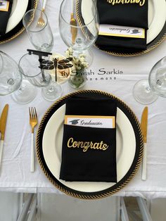 the table is set with black and gold place settings