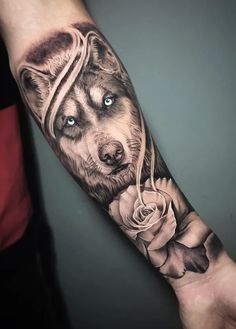 a man's arm with a wolf and rose tattoo on it