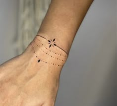 a person's hand with a small star tattoo on the left side of their wrist