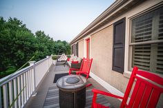 two red chairs sitting on top of a wooden deck