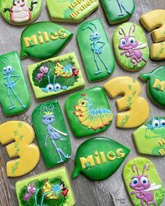 cookies decorated with the characters of bugs and aliens are displayed on a wooden table top