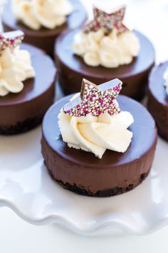 chocolate desserts with white frosting and sprinkles on a platter