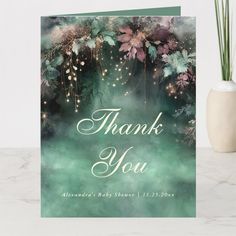 a thank you card with flowers and sparkles in the background on a marble surface