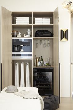 an open closet with towels and other items on the shelves in front of it,