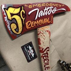 there is a sign that says emergency 5 tattoo removal on the back of a baseball bat