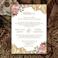 an ornate wedding card with pink roses and gold foil on it, surrounded by other flowers