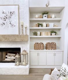 a living room filled with furniture and a fire place in front of a white brick wall