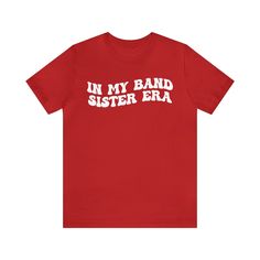 In My Band Sister Era Shirt, Gift for Sister, Shirt for Band, Band Sister Tee, Band Shirt for Sister, Gift for Band Sister 💫Dual side seams hold the garment's shape for longer. 💫100% Airlume combed and ringspun cotton (fiber content may vary for different colors) 💫Light fabric 💫Runs true to size 📢 Contact us if you need more information: 👉🏿Designed specifically for individuals, companies, groups, families, or any customized idea on a shirt. 👉🏿Buy a quantity of 10 shirts or more to recei Red Cotton Band Merch Top, Band Merch Cotton Tops With Funny Text, Cotton Band Merch Top With Funny Text, Unisex Red T-shirt With Letter Print, Red Letter Print Unisex T-shirt, Red Letter Print T-shirt, Unisex Fit, Unisex Red Cotton Tops, Funny Unisex Tops With Name Print, Red Cotton Tops With Name Print