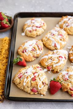 strawberry shortbread cookies with icing and strawberries on a baking sheet