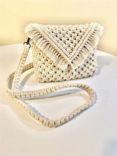 a crocheted white purse sitting on top of a table