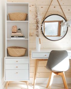 a white desk with a mirror and some baskets on top of it next to a chair