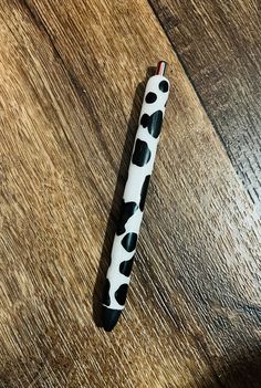 a black and white pen sitting on top of a wooden table