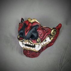 Samurai Foo Dog Mempo Mask This stylized mask is done in the style of traditional Samurai menpo. Painted in a black and red  acrylic paint with a gold metallic finish.This mask is large enough to be wearable by most people.Inside dimensions: 5.5 H x 6.25 W  x 6 D in / 140 H x 160 W x 150 D mmOverall Dimension: 5.5 H x 7.25 W x 6.5 D in / 140 H x 185 W x  165 D mmMade of PLA and hand painted in acrylics.Each piece is individually made to order so keep in mind:It will possibly take a couple weeks Samurai Half Mask, Mempo Mask, Black And Red Acrylic, Adam Lambert Concert, Noh Mask, Wolf Mask, Half Mask, Pokemon Cosplay, Foo Dog