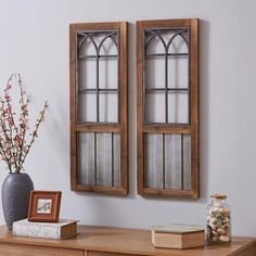 two wooden windows sitting on top of a dresser next to a vase with flowers in it