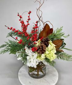 a glass vase filled with flowers and greenery