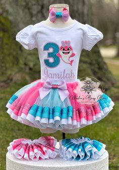 Shark Birthday Outfit, Shark Tutu Outfit, Girls Birthday Outfit, Doo Doo Doo, Birthday, Shark Birthday, Birthday Tutu, Baby Toddler Outfit This is a high-end boutique outfit. It is made with durable cotton embroidered T-shirts and premium vinyl, which is then pressed by an industrial-grade heat presser. The tutu is made with very soft tulle and doubled satin ribbon. All are designed to make your little one feel special on their big day! ---PROCESSING TIME IS CURRENTLY 2 weeks FROM DATE OF PURCHASE. PROCESSING TIME DOES NOT INCLUDE SHIPPING TIME WHICH WILL BE AN ADDITIONAL 3-5 BUSINESS DAYS. IF NEED BY DATE IS NOT GIVEN. YOUR ORDER WILL SHIP ON THE STANDARD SHIP DATE ON ETSY. IF NEED SOONER A RUSH UPGRADE CAN BE PURCHASED DURING CHECKOUT FOR AN ADDITIONAL COST. PLEASE MESSAGE ME FIRST WHAT' Baby Shark Birthday Outfit Girl, Cute Multicolor Birthday Party Supplies, Girls Birthday Outfit, Doo Doo, Headband Outfit, Birthday Girl Outfit, Shark Birthday, 1st Birthday Outfits, Tutu Outfits