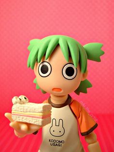 a toy doll holding a piece of cake