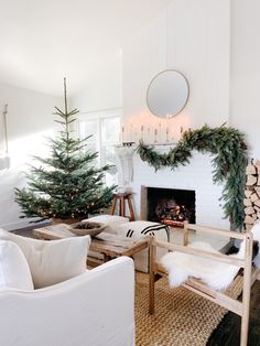 a living room filled with furniture and a fire place next to a christmas decorated tree