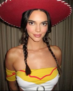 a woman wearing a red sombrero and braids