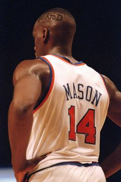 a close up of a basketball player with his back to the camera and hands on his hips