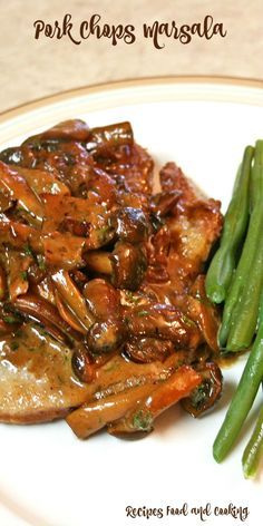 pork chops with mushrooms and green beans on a white plate, ready to be eaten