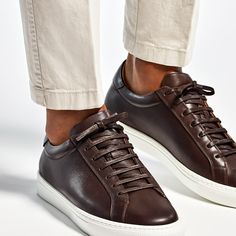 Crafted from supple calf leather, these brown sneakers feature a light brown leather lining and a white herringbone rubber sole. Classic Slip-on Sneakers With Leather Lining, Brown Calf Leather Sneakers With Stitched Sole, Luxury Sneakers With White Sole And Leather Lining, Brown Low-top Calf Leather Shoes, Brown Low-top Leather Shoes With Leather Sole, Luxury Brown Sneakers With Leather Sole, Brown Calf Leather Sneakers With Contrast Sole, Modern Brown Leather Sneakers, Brown Calf Leather Sneakers With Rubber Sole