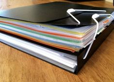 a stack of folders sitting on top of a wooden table